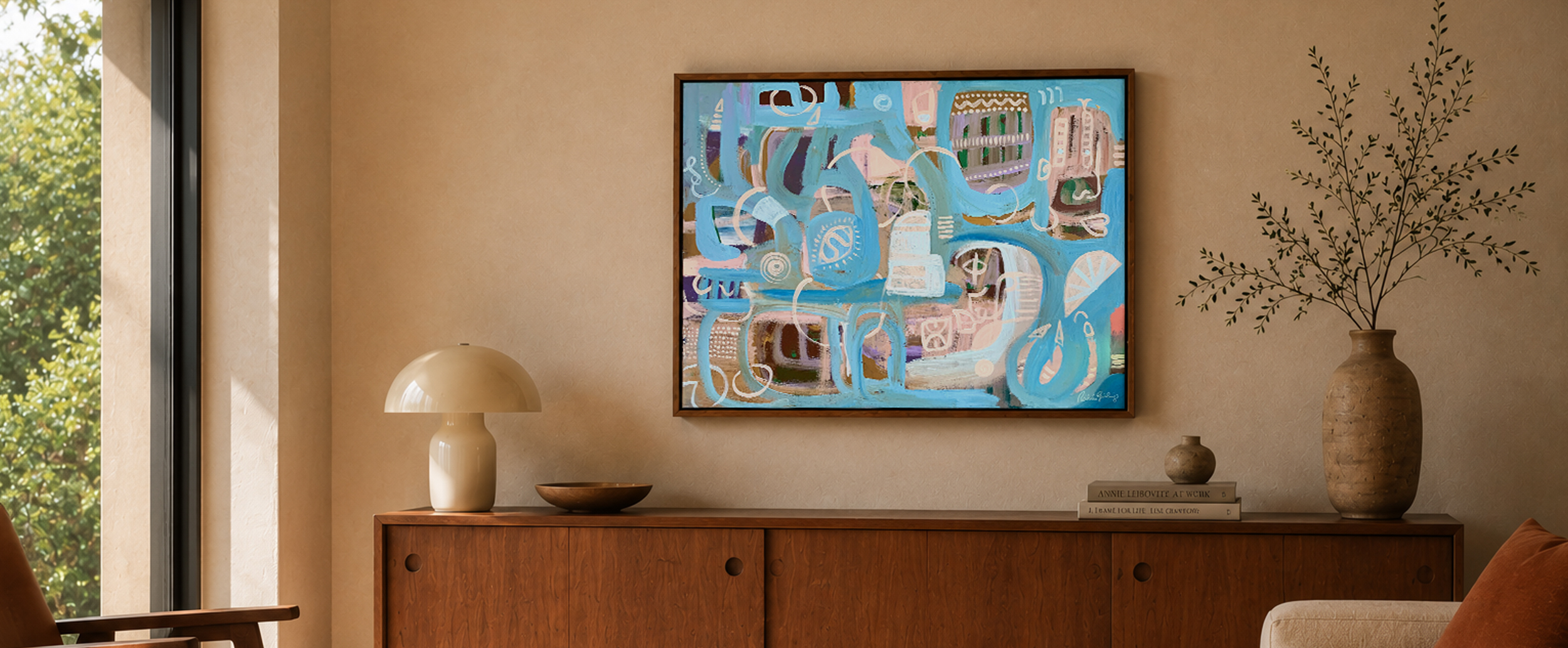 A framed commissioned canvas above a timber sideboard, painted to the room's warm register